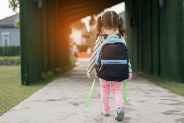 Young girl walking with a backpack