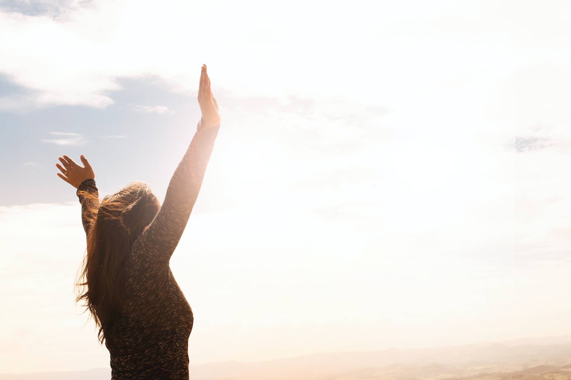 Woman lifting hands to sky